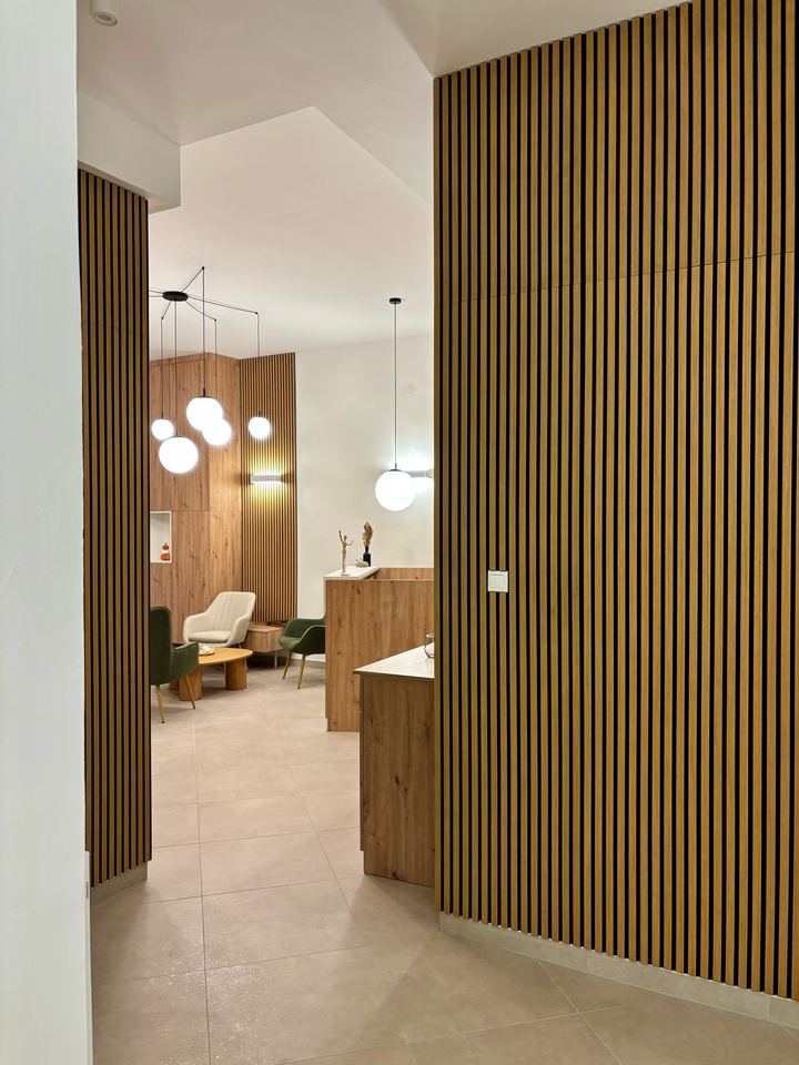 Nagyítás: Átlátás a lécezett fafalak között a váróra és a recepcióra